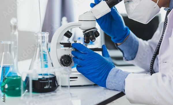 Obraz Scientist working microscope doing research in laboratory. Scientist in a lab, adjusting a microscope, evoking precision and scientific inquiry.