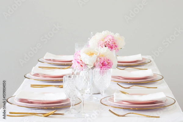 Fototapeta Elegant wedding table setting with pink peonies, gold cutlery, and crystal glassware, creating a romantic and sophisticated atmosphere.