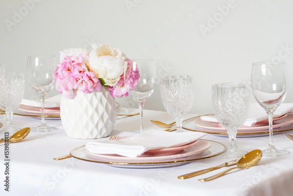 Fototapeta Elegant wedding table setting with pink peonies, gold cutlery, and crystal glassware, creating a romantic and sophisticated atmosphere.