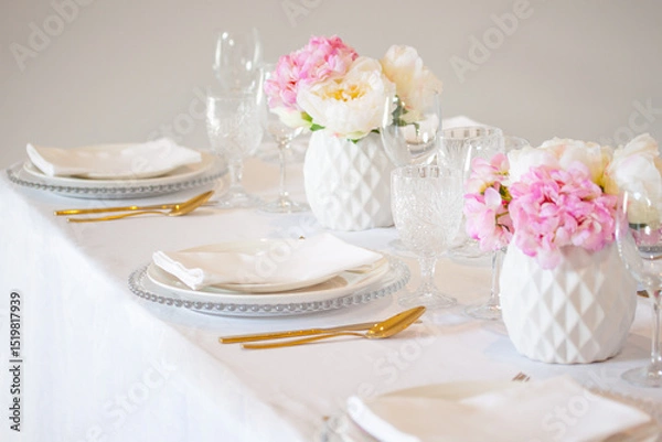 Fototapeta Elegant wedding table setting with pink peonies, gold cutlery, and crystal glassware, creating a romantic and sophisticated atmosphere.