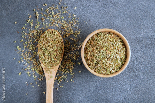 Fototapeta A bowl full of dried and ground natural mountain thyme on anthracite background