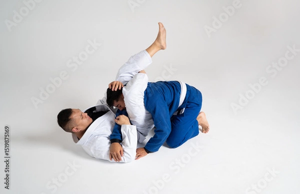 Fototapeta Two jiu jitsu athletes grappling on white background
