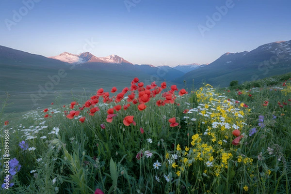 Obraz Scenic mountain landscape with wildflowers and majestic snow capped peaks at golden hour.