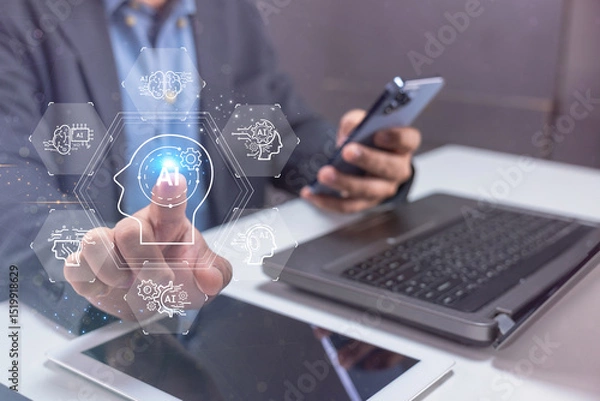 Fototapeta A person interacts with a virtual touchscreen interface displaying technology icons, working with a laptop, tablet, and smartphone.