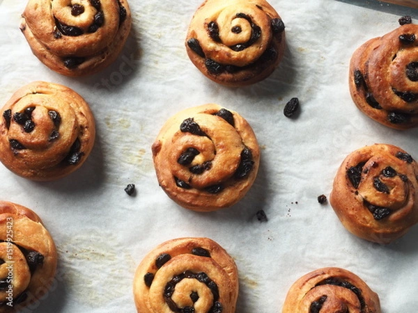 Fototapeta top view cinnamon raisin bread rolls on baking tray