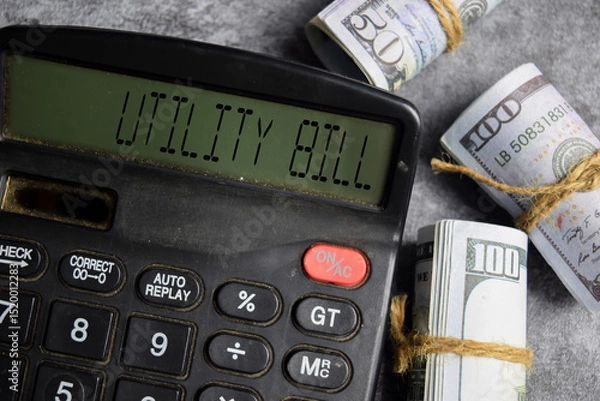 Obraz Dollar bills and calculator with text utility bill. Business and Financial conceptual