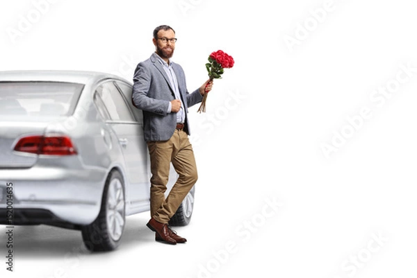 Fototapeta Man leaning on a car and holding a bunch of red roses