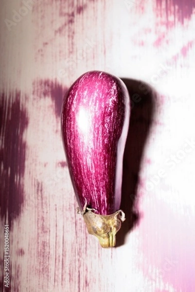 Obraz A striking graffiti eggplant stands as a focal point in a lively alley, its vivid colors contrasting against the textured backdrop. This unique piece captures the essence of urban creativity
