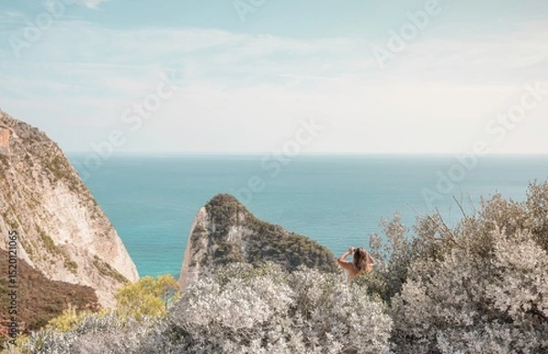 Obraz Gazing at the endless blue of the Ionian Sea, a solitary figure takes in the stunning cliffs and tranquil waters of Zakynthos. Summer warmth fills the air, inviting exploration and serenity