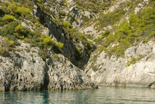 Obraz Kayaking through crystal-clear waters, surrounded by rugged cliffs and lush greenery, reveals the stunning natural beauty of Zakynthos during a warm summer day