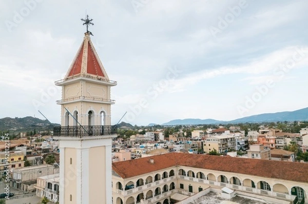 Obraz Nestled among stunning hills, Zakynthos showcases its charming architecture and vibrant local life during the summer. The warm sun illuminates historical buildings and lively streets
