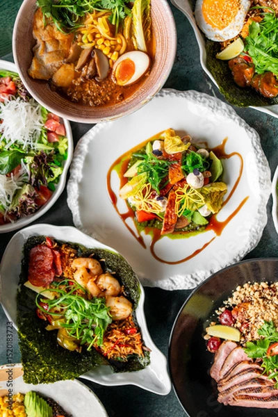Fototapeta A vibrant assortment of gourmet dishes including fresh salads, ramen, seafood, and meat, beautifully plated with colorful ingredients, showcasing culinary artistry and appetizing presentation