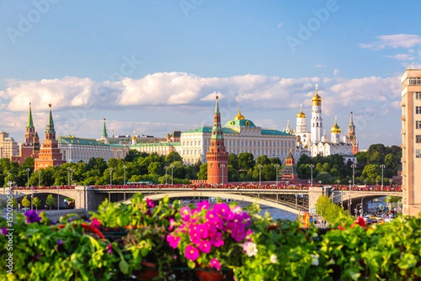 Obraz View of Moscow Kremlin, Moscow River and Big Stone bridge with pink flowers on the foreground during summer sunny day. Landmark in Moscow, Russia