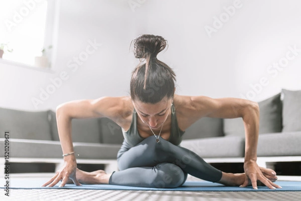 Obraz Yoga practice at home with a woman demonstrating flexibility and strength during a posture