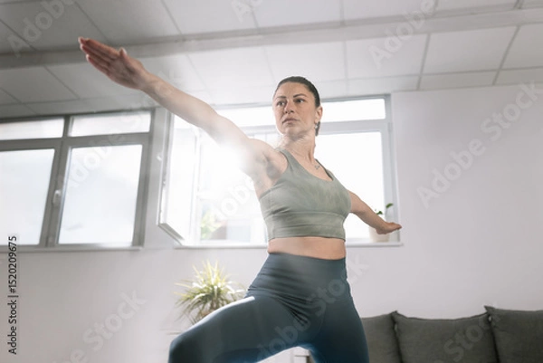 Obraz Yoga practice indoors with natural light shining through the windows in a serene environment