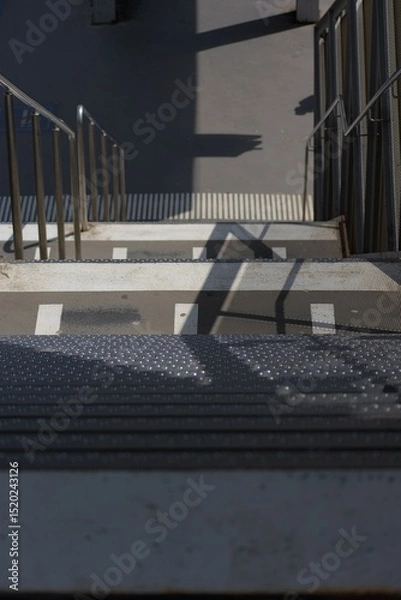 Fototapeta Striking shadows and strong lines define this urban staircase, showcasing modern design and stark contrasts in light and dark.