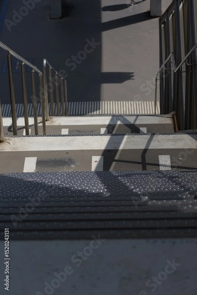 Fototapeta Striking shadows and strong lines define this urban staircase, showcasing modern design and stark contrasts in light and dark.