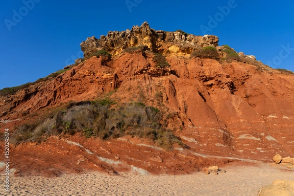 Fototapeta Telheiro beach at sunset in Sagres, Portugal, with its colorful cliffs.