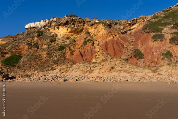 Fototapeta Telheiro beach at sunset in Sagres, Portugal, with its colorful cliffs.