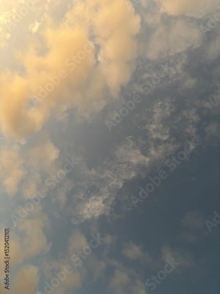 Fototapeta calm sky photo with soft and thin clouds golden light of the sun, light and shadow on the clouds create texture, bright blue sky calming background. Suitable for nature, tranquility, weather, freedom