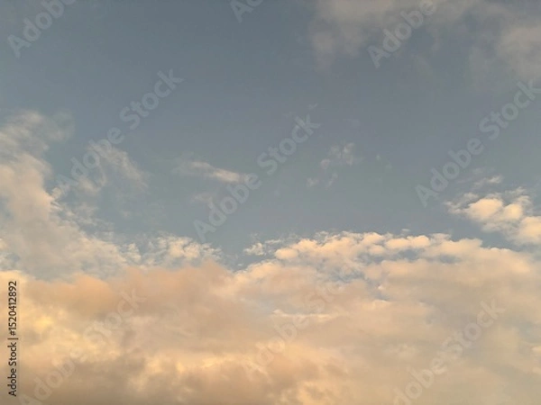 Obraz calm sky photo with soft and thin clouds golden light of the sun, light and shadow on the clouds create texture, bright blue sky calming background. Suitable for nature, tranquility, weather, freedom