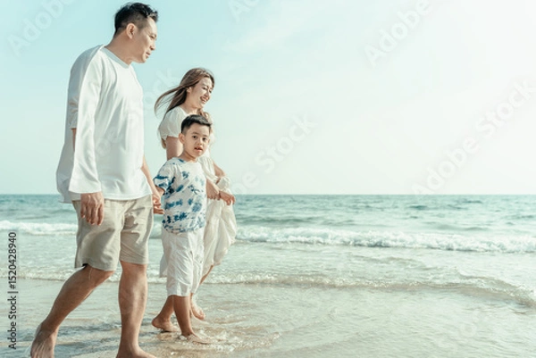 Fototapeta On vacation, travel, or a long weekend, spend time together with family and have fun and happiness by walking hand in hand on a beautiful beach with sunset light.