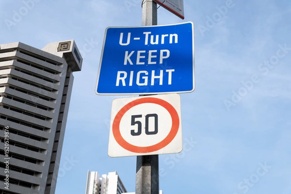 Fototapeta U-Turn road sign with speed limit in Orchard Road, Singapore skyline