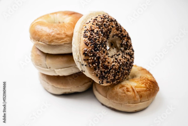 Fototapeta Closeup view of stack collection of bagel breads with various kind isolated over white background