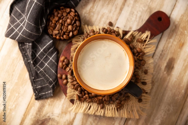 Fototapeta Flat white coffee in a black cup with coffee beans on rustic wooden table, french press on background.