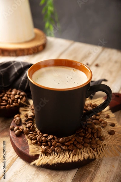 Fototapeta Flat white coffee in a black cup with coffee beans on rustic wooden table, french press on background.
