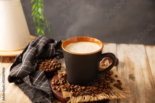 Fototapeta Flat white coffee in a black cup with coffee beans on rustic wooden table, french press on background.