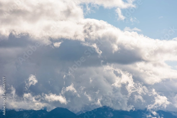Fototapeta heavy clouds on a blue sky above mountains september. dramatic view. early autumn cloudy weather over carpathian range. cloudscape vacation