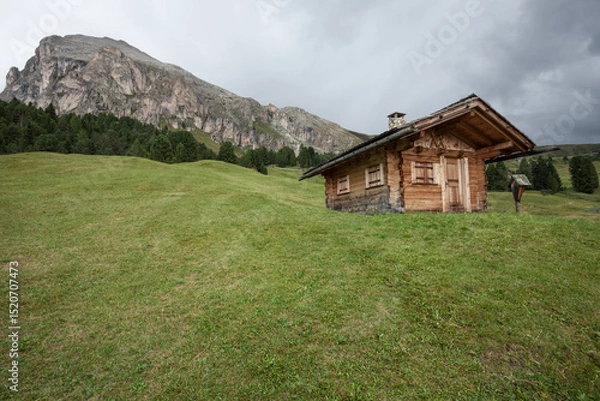 Obraz small house over a mountain pasture in Dolomites with wonderful panorama