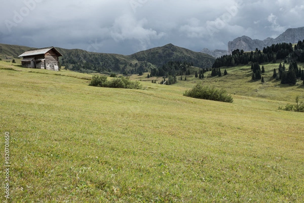 Obraz small house over a mountain pasture in Dolomites with wonderful panorama