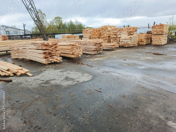 Fototapeta Boards and lumber are stacked in the open air.