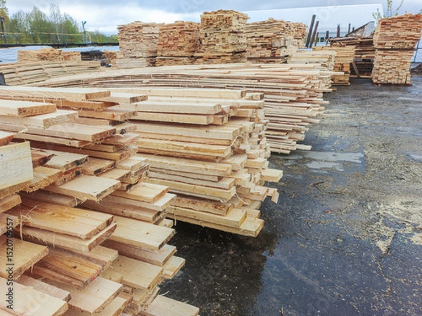 Fototapeta Boards and lumber are stacked in the open air.