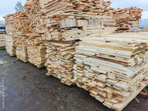 Fototapeta Boards and lumber are stacked in the open air.