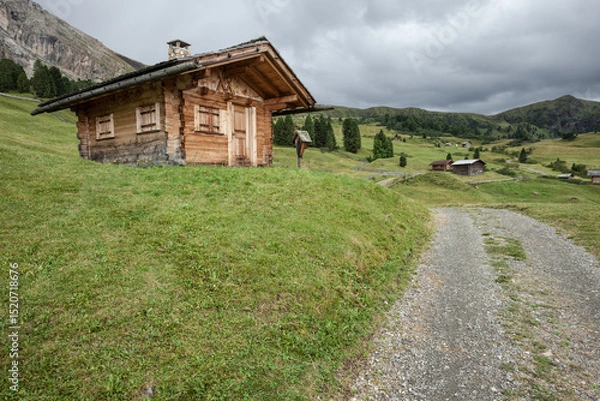 Obraz small house over a mountain pasture in Dolomites with wonderful panorama