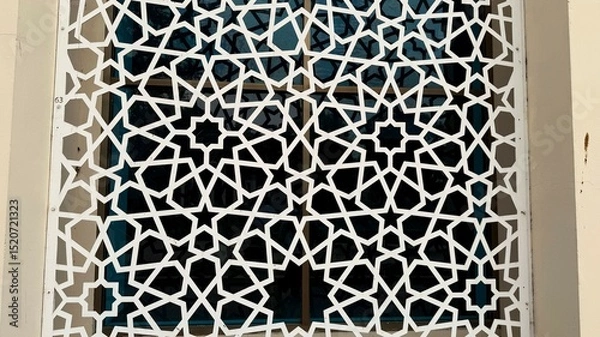 Fototapeta White Geometric Islamic Pattern Window Screen with Star Design against Dark Glass Background