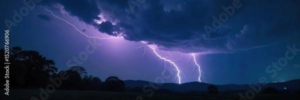Obraz Dramatic lightning strike illuminates a dark, stormy night sky over a silhouetted landscape of trees and hills The powerful bolt creates a breathtaking display of nature's raw energy , natural, flash