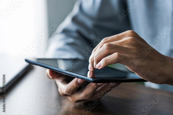 Fototapeta Business professional using tablet to manage information and reviewing documents