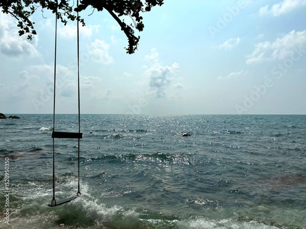 Fototapeta Wooden Swing Hanging Over the Sea with Blue Sky and Clouds in the Background at Hanuman Bay, Koh Samui, Thailand