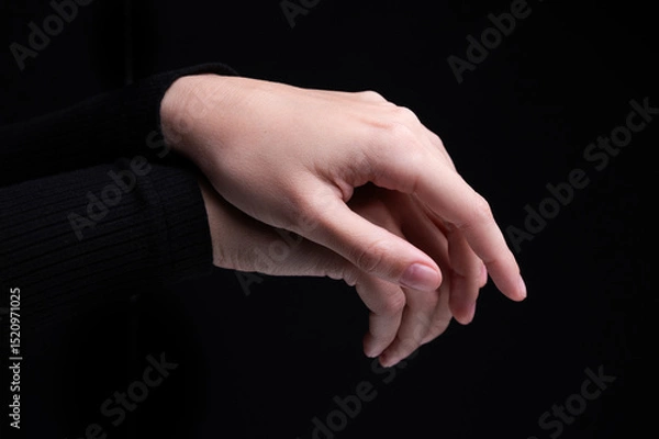 Obraz Female hands on a black background. Concept of tenderness and self-care.
