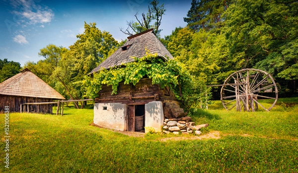 Obraz Sunny summer view of traditional romanian wooden peasant houses. Wonderful rural scene of Transylvania, Romania, Europe. Beauty of countryside concept background..
