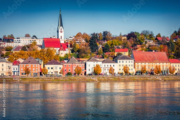 Obraz Bright buildings on the shore of Danube river. Sunny autumn cityscape of Mauthausen market town in state of Upper Austria, Europe. Traveling concept background.