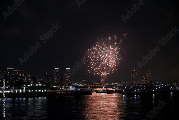 Fototapeta A vibrant firework display lights up the sky above the beautiful Yokohama skyline