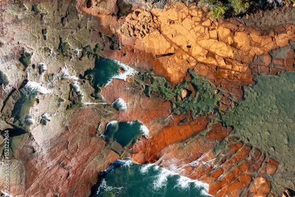 Fototapeta Aerial view of a rugged, rocky shoreline with tide pools