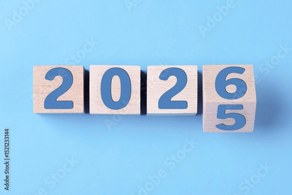 Fototapeta 2026 Happy New Year. Wooden cube block change from 2025 to 2026 on blue. Concept 2026 New Year background. Business, resolutions, goals, inspiration, success, ideas