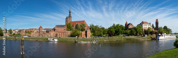 Fototapeta Panoramic view of Tangermünde on Elbe river with city wall, St Stephens church, castle and retired river cruise ship