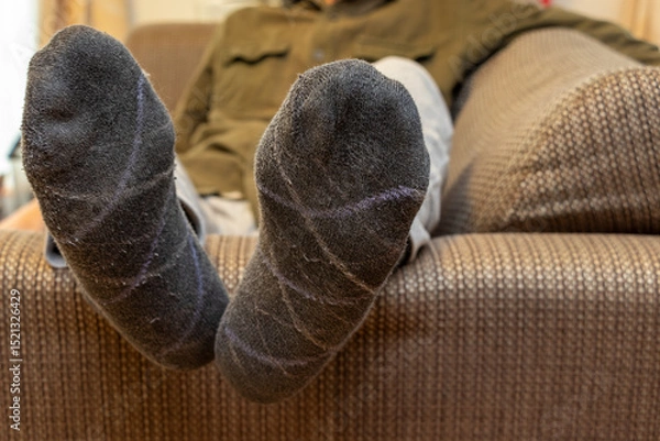 Obraz ソファーに横たわる男性の足
